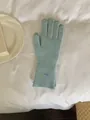 Close-up detail of soft light blue knitted winter gloves with small oval metal tag - Gloves Only / Sky Blue