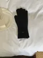 Solid black knitted winter glove for women featuring a decorative oval metal tag detail - Gloves Only / Black