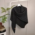 Detailweergave van een zwarte gebreide wollen sjaal met pailletten op een witte hanger. - Tops / 175x75cm / Zwart