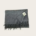 Detailed macro shot of a gray 100% Australian wool scarf with fringe and care label - Charcoal Gray