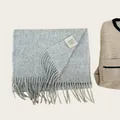 Macro detail of a 100% Australian wool scarf showing soft texture and material label - Smoke