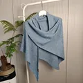 Blauwe gebreide wollen sjaal met pailletten detail, hangend aan een wit kledingrekje. - Tops / 175x75cm / Leigrijs