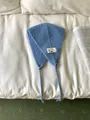 Retro sky blue knitted ear warmer for women featuring vintage label and functional ties - One Size / Blue