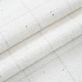 High-quality close-up view of white tweed fabric with silver sequins and checkered pattern - Off White