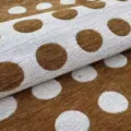 Detail view of thick chenille jacquard fabric with retro white and brown polka dot pattern - 145cm Wide / Yellow