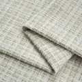 Macro close-up of premium beige shiny tweed fabric with intricate woven metallic threads. - No.9 Matcha Green