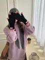 Close-up of stylish black coral fleece winter gloves with pink fingertips on a model - One Size / Black