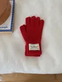 Warm red knitted winter glove with stylish white fabric label on the wrist cuff - One Size / Red