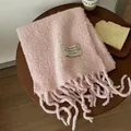 Soft pink wool fringe scarf with embroidered Undertonen brand label on a wooden table - Pink