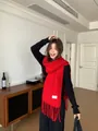 Premium vibrant red wool blend tassel scarf shown on an Asian model in a cozy room. - Red