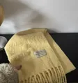 Soft thick yellow wool scarf with tassels, featuring a minimalist studio brand label. - Yellow