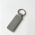 Llavero rectangular minimalista de cuero PU gris con un anillo de metal pulido - Gris