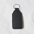 Llavero minimalista de cuero negro con anillo plateado sobre fondo de tela blanca - Negro
