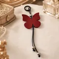 Élégant porte-clés papillon en cuir bordeaux avec des détails de perles argentées - Bordeaux