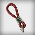 Detailed view of red braided leather car keychain featuring silver VIP engraved metal buckle - VIP Lettering Design / Dark Red