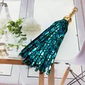 Detailed view of a metallic turquoise leather tassel keychain with golden metal ring and cap - 15cm / Lake Blue (Scales Pattern)