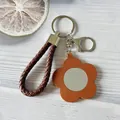 Portachiavi alla moda in pelle intrecciata con fiore arancione e mini specchio portatile - Marrone chiaro