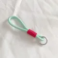 Detalle del cordón trenzado verde menta con funda roja estriada y anillo plateado - Estilo Verde y Rojo (12)