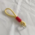 Detail view of a yellow and red braided lanyard featuring a silver spring metal ring clasp - Yellow and Red Style (1)