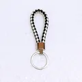 Close-up detail of black and white woven leather cord keychain with silver ring - 50 Pieces/Pack / White and Black