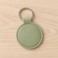 Elegant sage green round PU leather keychain featuring silver metal ring and stitched edge detail - Light Green