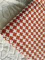Close-up of orange and white houndstooth checkered linen fabric for upholstery - Orange