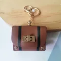 Retro brown leather mini bag keychain charm with black stripes and an elegant white pearl - Brown