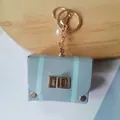 Vintage mini grey leather bag keychain with blue stripes and elegant pearl charm detail - Light Blue