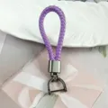 Detail shot of purple braided leather keychain with gunmetal horseshoe clasp on gift box - Purple