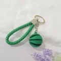 Primer plano de un llavero de baloncesto verde con una correa de muñeca trenzada - Verde