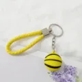 Primer plano detallado de la correa trenzada amarilla y el dije de baloncesto 3D colgante. - Amarillo