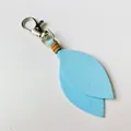 Detail of light blue suede leaf keychain with silver lobster clasp and leather wrap - Blue