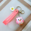 Gros plan d'un porte-clés hibou rose avec marguerite et lanière en relief rose - Rose