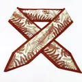 Détail d'un élégant ruban à cheveux avec imprimé botanique de fougères aux tons marron et blanc. - Foulard Rouge Pointu