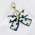 Porte-clés élégant avec nœud en tissu à pois vintage et breloque en métal doré - Bijou de Noeud à Pois Bleu Foncé