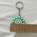 Gros plan d'un porte-clés flocon de neige en silicone vert et blanc mesuré par une règle - Flocon de Neige Vert (Style Chaîne)