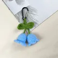 Close-up of handmade crochet blue lily of the valley keychain with black carabiner - Blue
