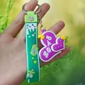 Macro detail of a 3D purple silicone heart keychain with a green decorative strap - Strap Purple Heart