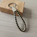 Elegante llavero de cuero trenzado en negro y dorado metalizado para coche - Negro y Dorado