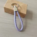 Elegante llavero de cuero trenzado violeta con anillo metálico y caja de regalo - Violeta Claro