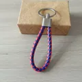 Llavero de cordón de cuero trenzado hecho a mano en rojo y azul con un anillo de metal plateado - Estilo Azul y Rojo