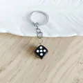 Creative black acrylic dice keychain accessory with silver metal ring on light wood - Black
