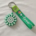 Détail d'un porte-clés de Noël en silicone vert avec flocon de neige et mot Love - Flocon de Neige Vert (Style Cordon)
