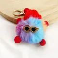 Detailed macro view of a colorful furry pom-pom keychain with a red hat and golden sunglasses - Size 4
