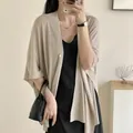 Close-up of lightweight beige sun protection shawl cardigan worn over a black dress - One Size / Robe / Camel