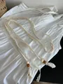 Detailed view of Bohemian woven cotton belt with beads and decorative tassels - Lace Tassel Wood Bead Style / Off White
