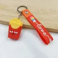 Détail d'un porte-clés mignon en forme de frites avec une lanière en silicone rouge et métal. - Frites