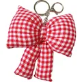 Gros plan détaillé d'un porte-clés en forme de nœud en tissu vichy rouge et blanc - Rouge