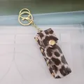 Stylish leopard print PU leather lipstick holder keychain with golden metal hardware - Beige