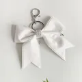 Élégant porte-clés nœud en ruban blanc pailleté avec strass brillants et anneau argenté. - Blanc
